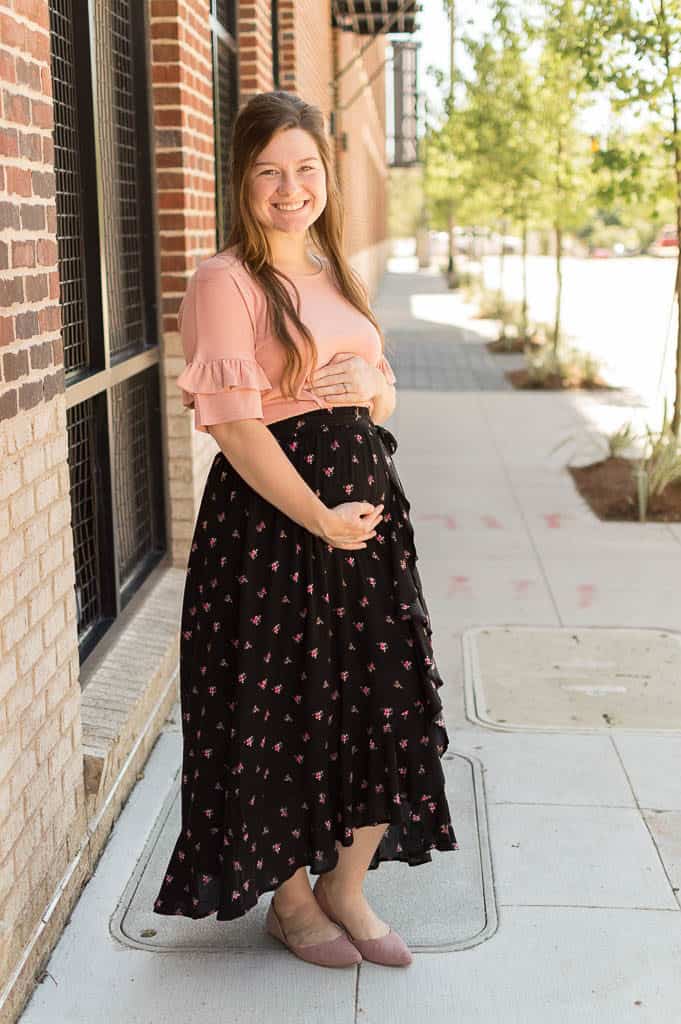woman wearing modest clothes holding her belly.