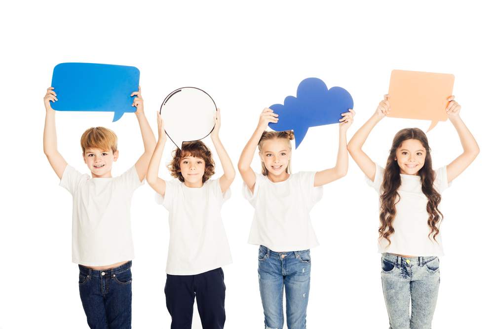 Children, all holding speech bubbles of different shapes and sizes, but no words, above their heads.