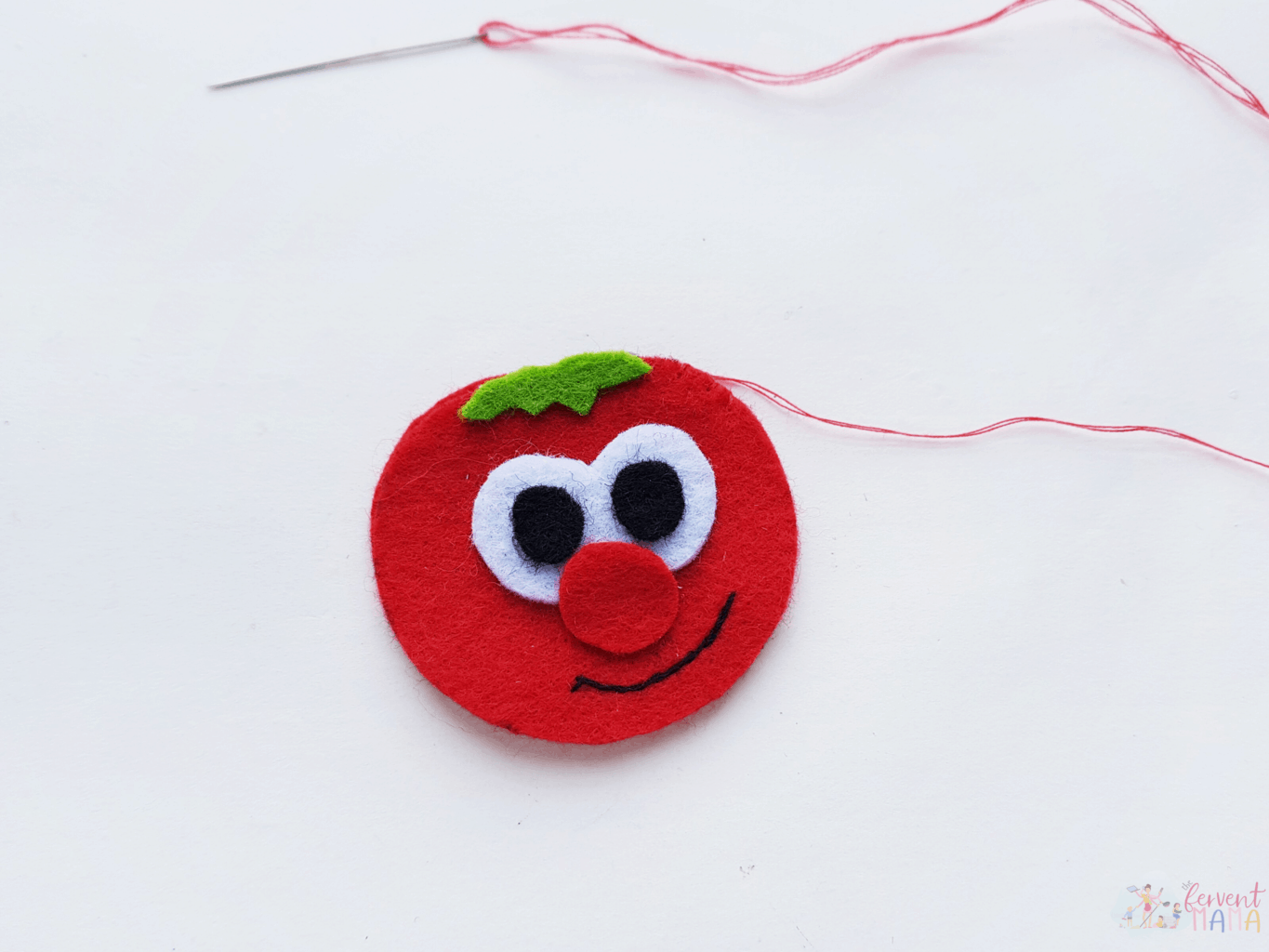 Showing a photo of a red tomato being sewn together to complete a Christian show inspired plush toy craft.